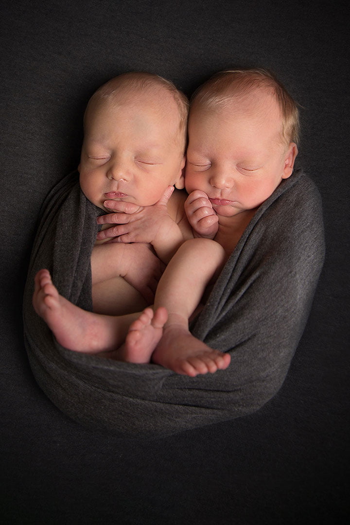 newborn twins sleeping in grey blanket in photography studio by Newborn Photographer Bradford and Leeds